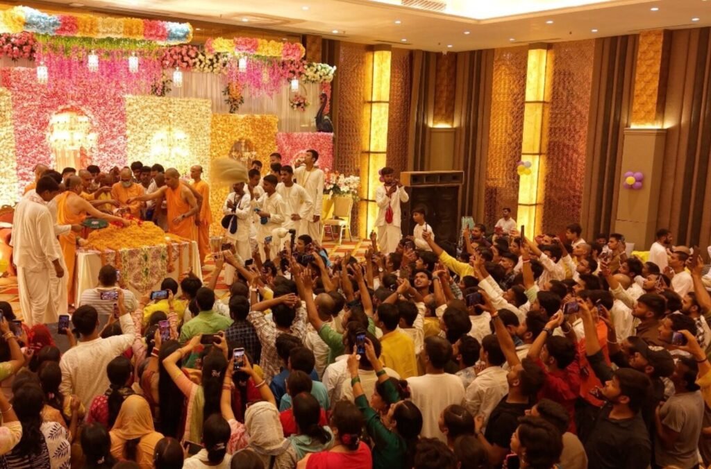 Devotees filling a festival hall for kirtan